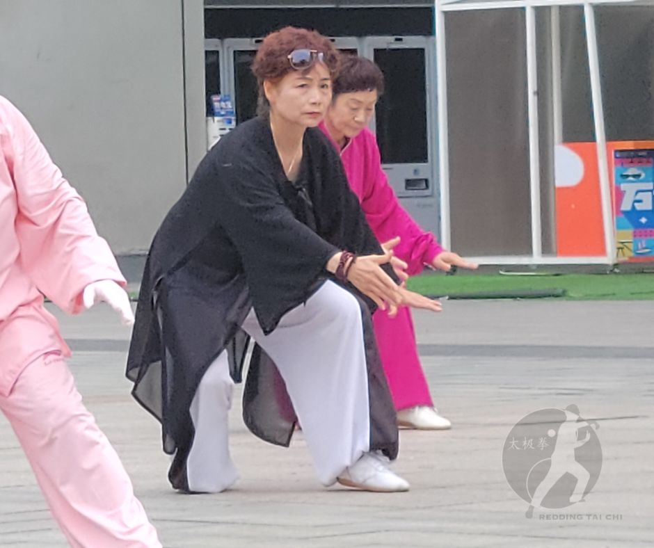 Women practicing the Tai Chi movement "Needle to the Sea Bottom" outdoors in Xi'an, China. Picture copyright, Redding Tai Chi 2024